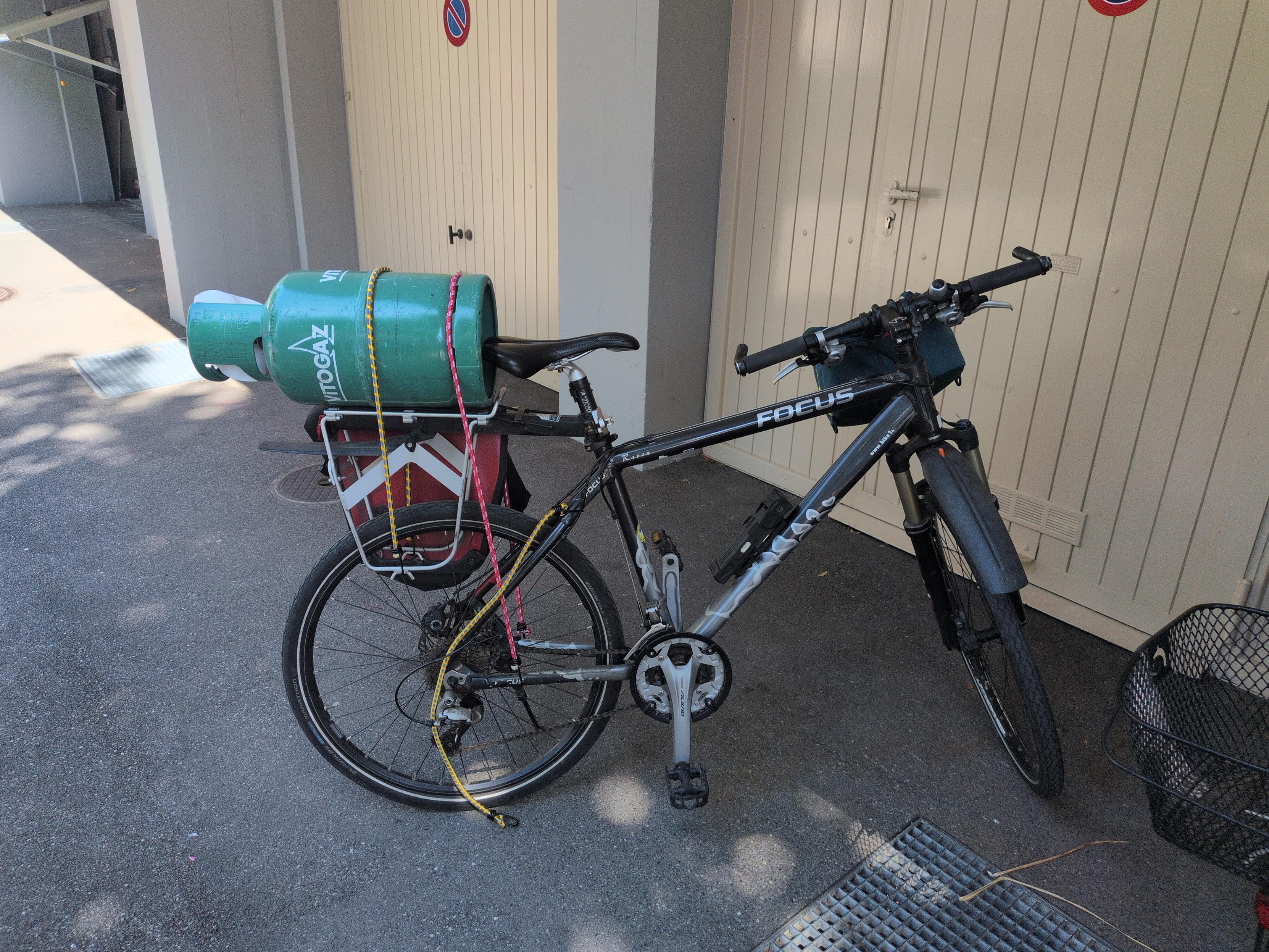 My bicycle, with a green gas bottle strapped to the rack.