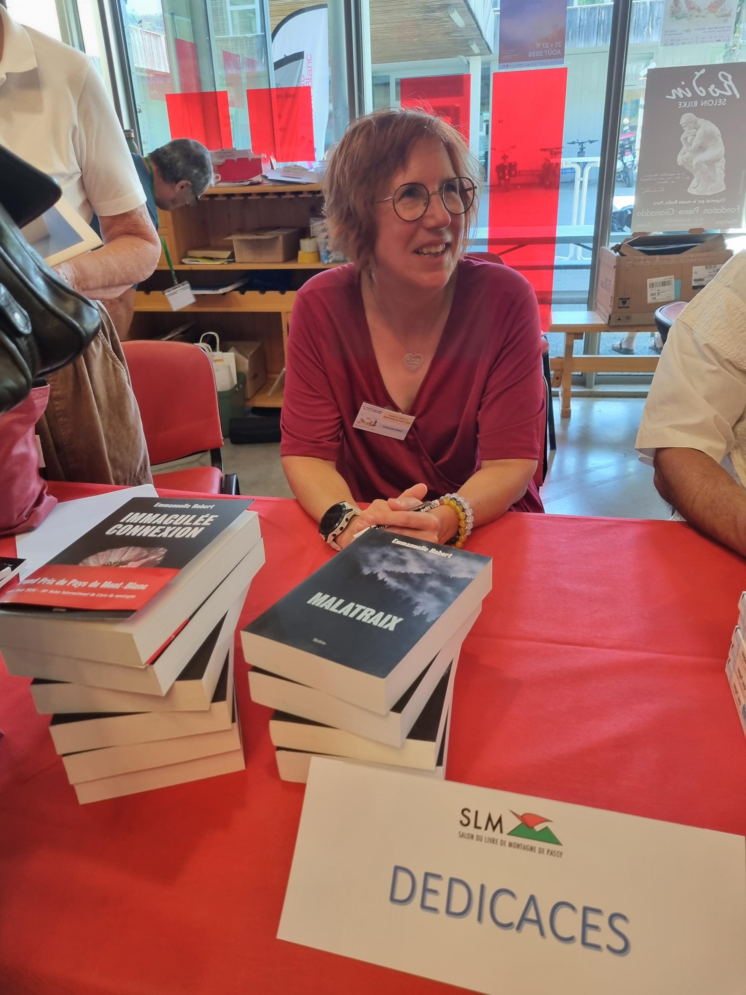 Immaculée connexion (Slatkine), ornée du bandeau rouge du Grand Prix du Pays du Mont-Blanc, et ma pomme en dédicace au Salon international du livre de montagne de Passy (France).